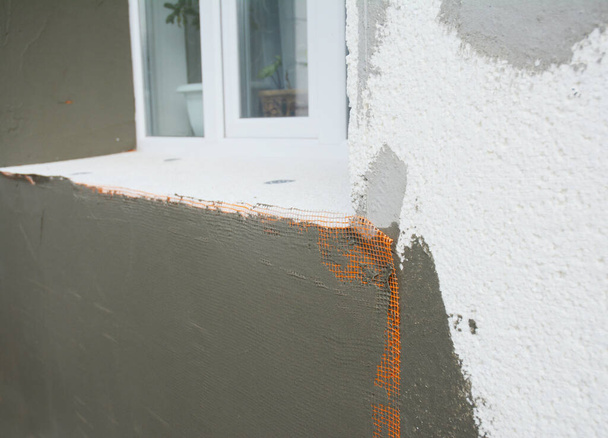 Plâtrage, revêtement écrémé du mur de la maison avec du ciment autour de la fenêtre à l'extérieur
. - Photo, image
