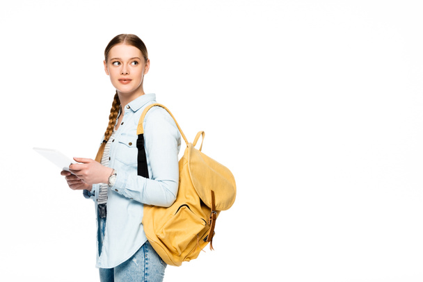 estudante bonita com mochila usando tablet digital e olhando para longe isolado em branco
 - Foto, Imagem