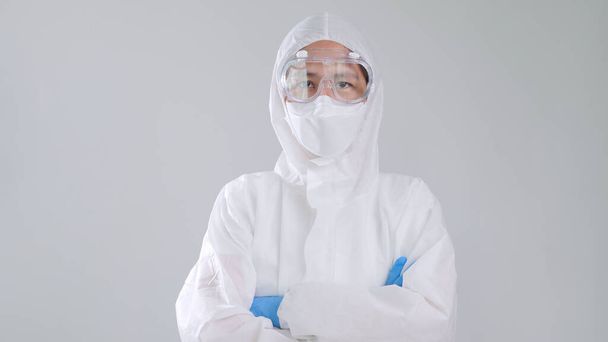 Portret vertrouwen Aziatische arts in beschermende PPE pak dragen gezichtsmasker en bril - Foto, afbeelding