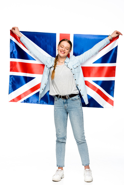 İngiliz bayrağını tutan mutlu, güzel kız beyazların üzerinde izole edilmiş. - Fotoğraf, Görsel