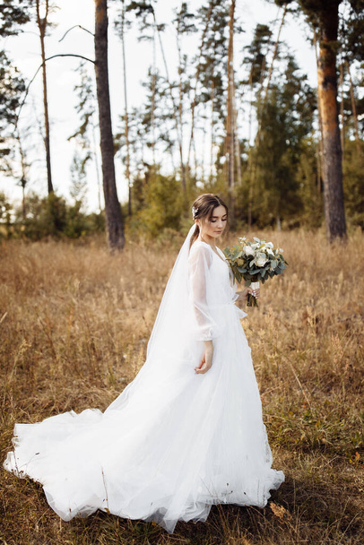 Delicate beautiful  bride with flowers  in the forest - Fotó, kép