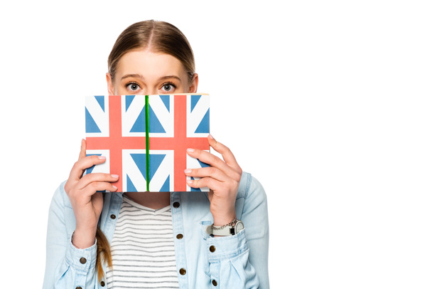 pretty girl with braid and obscure face holding book with uk flag isolated on white - Photo, Image
