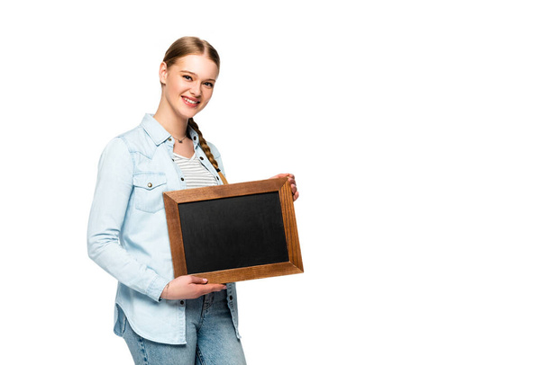 smiling pretty girl with braid holding empty chalkboard isolated on white - Foto, Bild