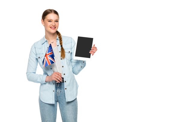 усміхнена красива дівчина з тасьмою, що тримає цифровий планшет з порожнім екраном та українським прапором ізольовано на білому
 - Фото, зображення