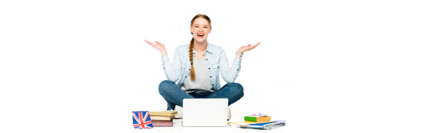 onnellinen tyttö istuu lattialla kannettavan tietokoneen, kirjoja ja copybooks, uk lippu ja eleiden eristetty valkoinen, panoraama laukaus
 - Valokuva, kuva