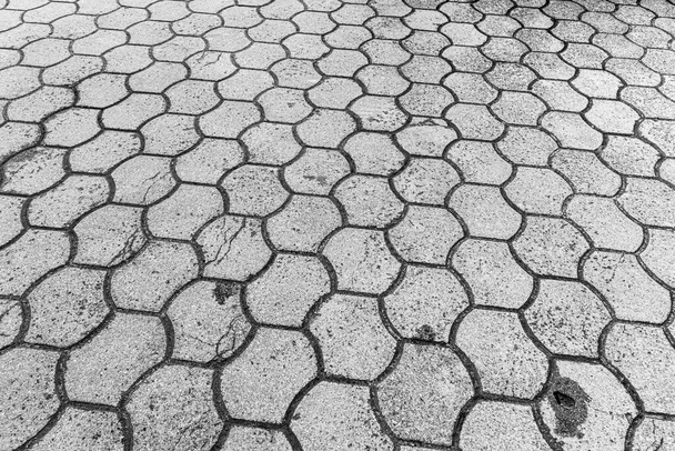 Pohled shora na šedou jednobarevnou šestiúhelníkovou dlažební kamennou cestu. Stará dlažba žulové struktury. Pouliční dlažební chodník. Abstraktní pozadí pro design. - Fotografie, Obrázek