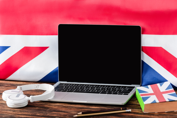 laptop near book with uk flag and headphones on wooden table - Photo, Image
