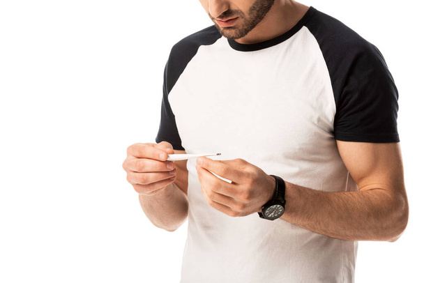 bijgesneden beeld van zieke man met digitale thermometer geïsoleerd op wit  - Foto, afbeelding