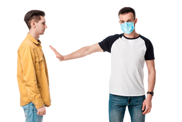 man in medical mask showing stop gesture near guy isolated on white  - Photo, Image