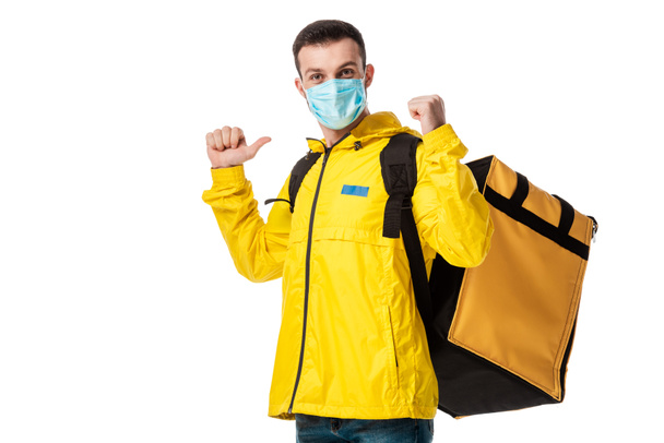 repartidor en máscara médica y mochila con orden que muestra el pulgar hacia arriba aislado en blanco
  - Foto, Imagen