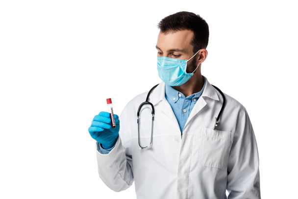 orvos orvosi maszk és fehér köpeny nézi kémcső minta és koronavírus betűkkel izolált fehér  - Fotó, kép