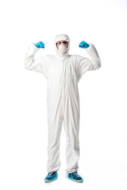 strong man in hazmat suit, medical mask, goggles and latex gloves standing isolated on white  - Photo, Image