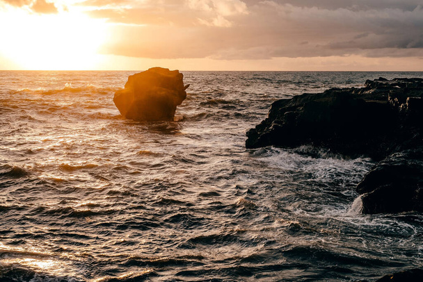 Waves crashing over rock formation cliffs at sunset with beautiful light - Foto, Imagem