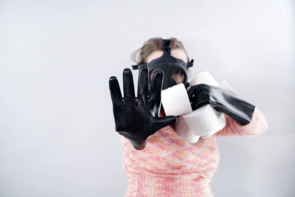 femme effrayée dans un masque à gaz et gants prend tout le papier toilette du magasin pendant l'épidémie de covidé coronovirus
. - Photo, image