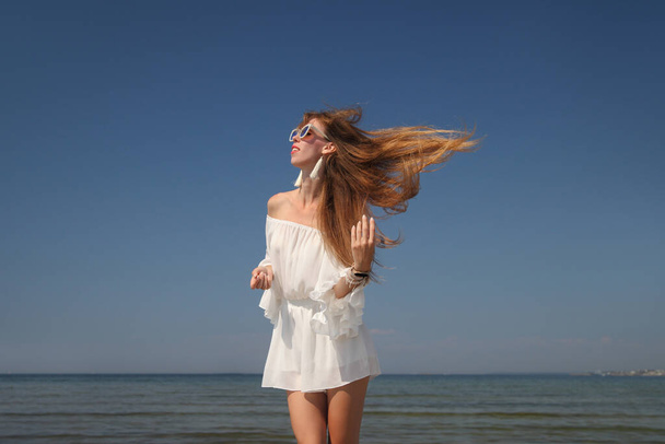 feliz joven en un vestido blanco junto al mar
 - Foto, imagen
