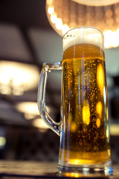 glass of beer on a table in a bar - Foto, Imagen
