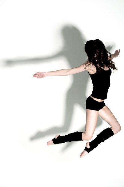 Gymnast jumping in studio with hard light - Foto, Imagen