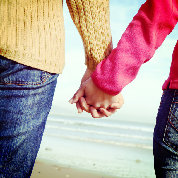 Gli amanti coppia che si tiene per mano in spiaggia
 - Foto, immagini