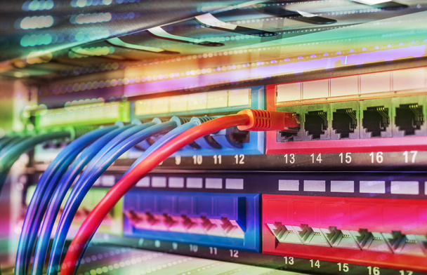 データサーバールームのブラックパッチパネルに接続された青と赤のインターネットパッチコードケーブルを持つサーバーラック - 写真・画像