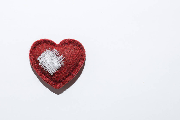 red textured heart on a white background with a bandage, the concept of recovery - Fotografie, Obrázek