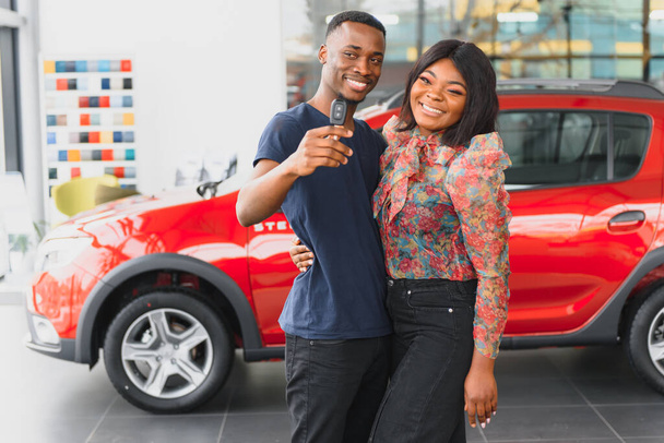 щаслива африканська пара вибирає розкішний автомобіль в автосалоні, дивлячись на інтер'єр
 - Фото, зображення