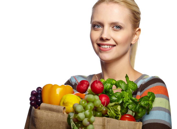 Elinde taze sebzelerle dolu alışveriş poşeti tutan bir kadın. Beyaz arka planda izole edilmiş sağlıklı beslenme kavramı - Fotoğraf, Görsel