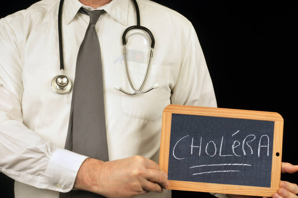 Docteur tenant une ardoise scolaire avec du choléra écrit dessus
 - Photo, image