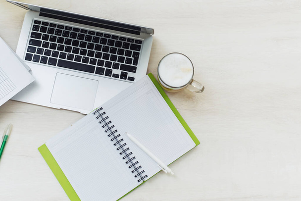 Mesa de escritório com vista superior com laptop, notebooks e xícara de café em fundo de cor branca. Mesa de escritório com notebook em branco e laptop
. - Foto, Imagem