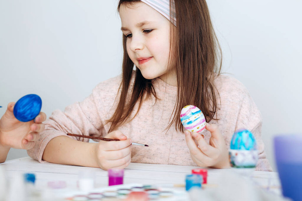 easter, family, holiday and child concept - close up of little girl coloring eggs for easter - Foto, Bild