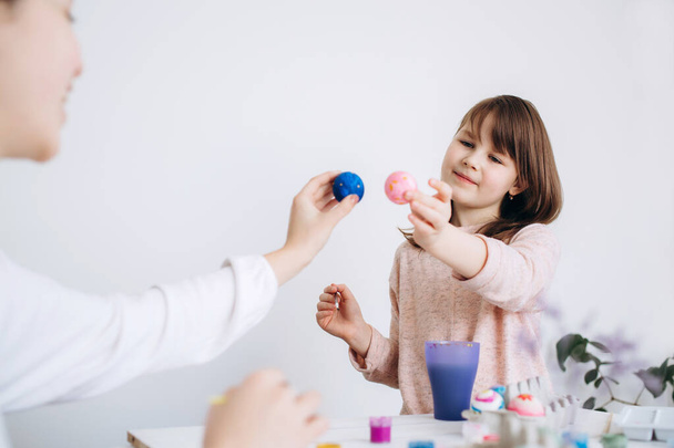 Happy Easter concept. Family preparing for Easter celebration. Art and craft concept with female hands and paiting eggs by girls - Фото, изображение