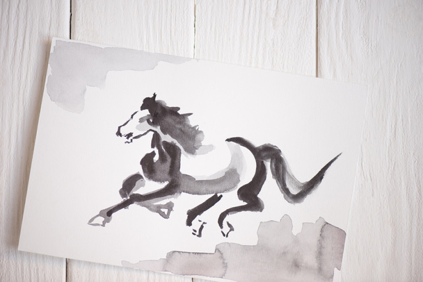 Vista superior de papel com pintura japonesa com cavalo sobre fundo de madeira
 - Foto, Imagem
