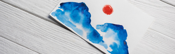 Top view of paper with Japanese painting with clouds and sun on wooden background, panoramic shot - Foto, Imagem