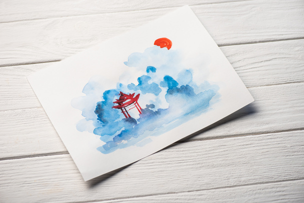 High angle view of paper with Japanese painting with temple on wooden background - Photo, Image