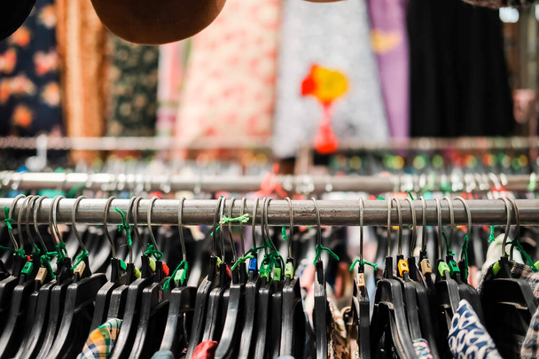 Overhemden op hangers in lokale kledingwinkel in Thailand markt met wazige achtergrond. - Foto, afbeelding