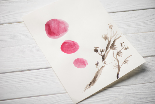Hochwinkelansicht des Papiers mit japanischer Malerei mit Pflanzen und rosa Kreisen auf Holzgrund - Foto, Bild