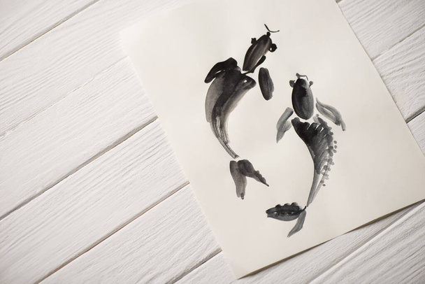 Vue du dessus de l'image avec peinture japonaise avec des poissons gris sur fond en bois
 - Photo, image