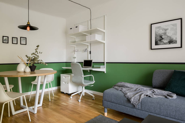 緑の壁と木製の床のアパートのスタイリッシュなリビングルーム - 写真・画像