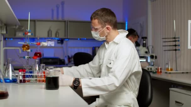 Científico joven mezclando líquidos de color
 - Metraje, vídeo