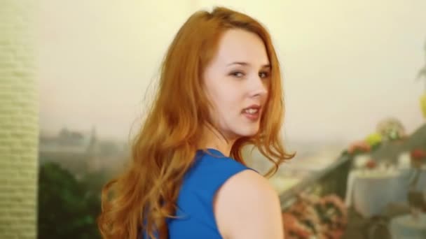 The beautiful sexy girl with red hair and playful look is spinning and smiling - Footage, Video