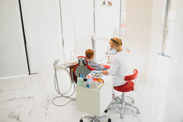 Female dentist and child in a dentist office - Фото, зображення