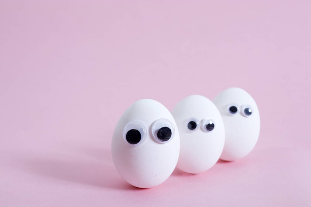 concept social networks communication and emotions - eggs wink on pink background. Copy space - Fotoğraf, Görsel
