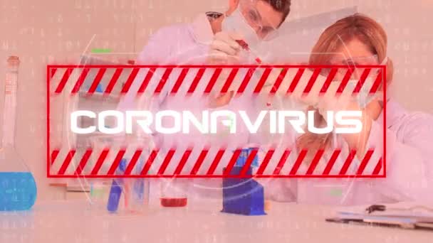 Animation of the word Coronavirus written in white in red frame, data processing, coronavirus Covid-19 spreading over male and female doctors scientists working in a laboratory in the background. - Πλάνα, βίντεο