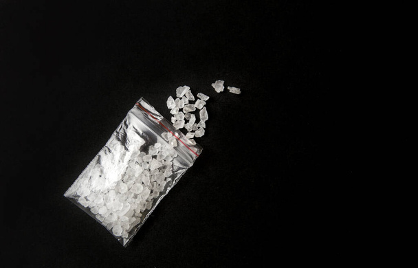 Immagine concettuale di "sali da bagno" sintetico cathinones droga concetto di narcotici. Polvere di cristallo bianco su sfondo nero (impostato), simile al sale da bagno
. - Foto, immagini