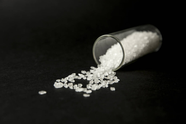 Fogalmi kép a "bath sók" szintetikus katinonok kábítószer-koncepció. Fehér kristály por fekete háttér (set up), hasonlít a fürdőszoba só. - Fotó, kép
