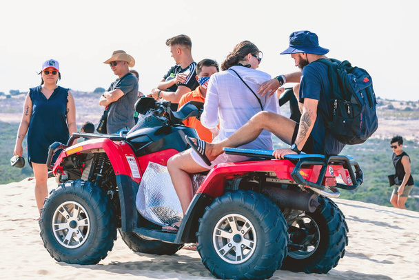 MUI NE-VIETNAM-APRIL 24, 2019 : Les touristes non identifiés aiment faire du quad ou des VTT rapides à quatre roues motrices dans les dunes de sable blanc le 24 avril 2019 à Mui Ne, Vietnam. - Photo, image