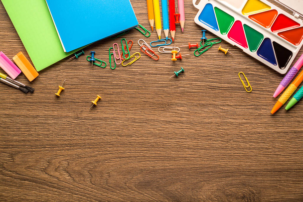 Bright school accessories and stationery on a wooden background, with copy space, top view - Photo, Image