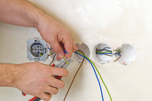 Elektriker installieren Steckdosen an beiger Wand mit EU-Standards - Foto, Bild