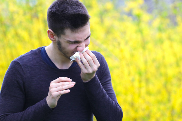 Симптом Ковид-19, молодой человек кашляет в бумаге
 - Фото, изображение