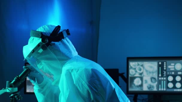 Wissenschaftler in Schutzanzügen und Masken arbeiten im Forschungslabor mit Laborausrüstung: Mikroskope, Reagenzgläser. Coronavirus 2019-ncov hazard, pharmazeutische Entdeckung, Bakteriologie und Virologie-Konzept. - Filmmaterial, Video