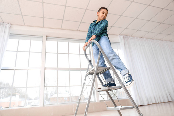 Un bambino afro-americano che gioca con la scala a gradini a casa. Bambino in pericolo
 - Foto, immagini